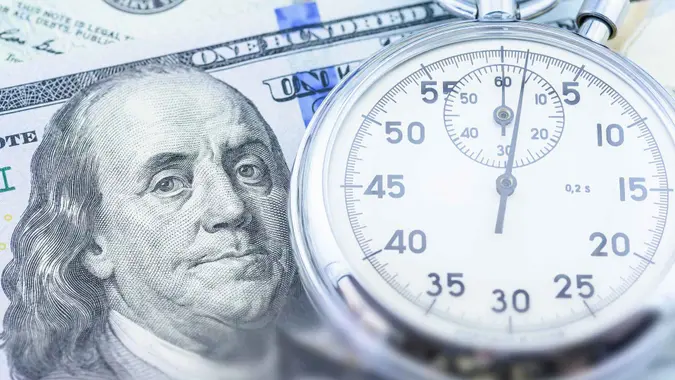 时间就是金钱,资产增长的价值随着时间的推移,金融概念:美国美元美元用秒表,描述投资者对未来收入存款或投资高收益债券或增加利润。