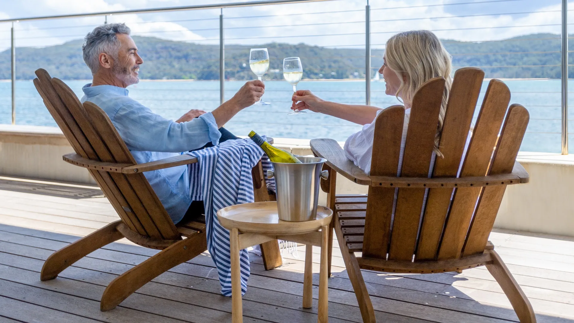 Mature couple drinking wine out on the deck. stock photo