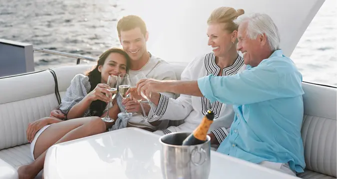 Two generational family celebrating with champagne on yacht.