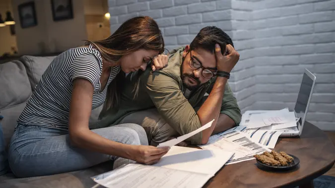 Worried young couple with financial bills stock photo