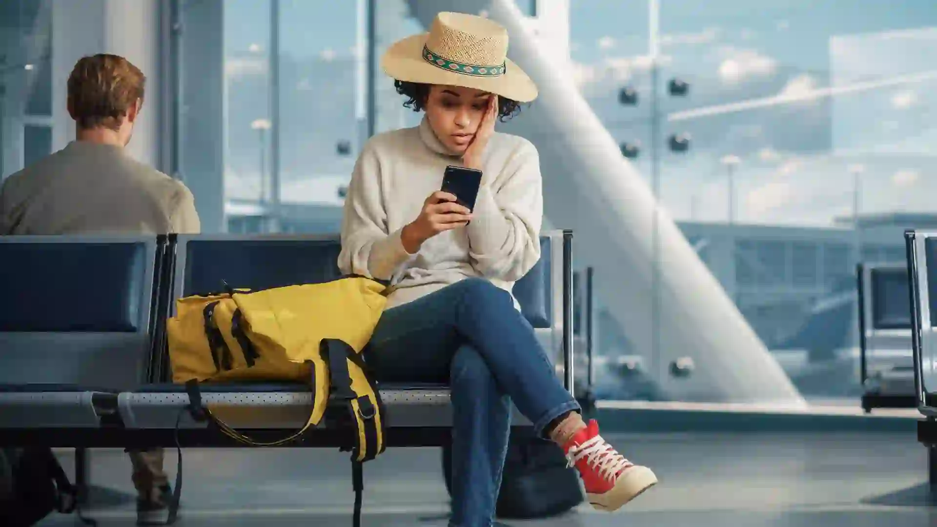 A woman sits in an airport terminal upset over delayed or canceled flight.