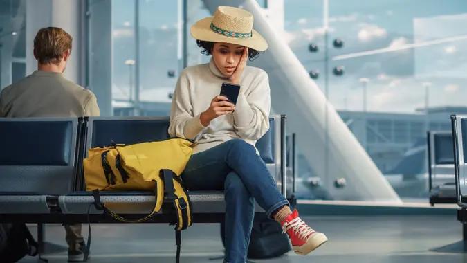 A woman sits in an airport terminal.