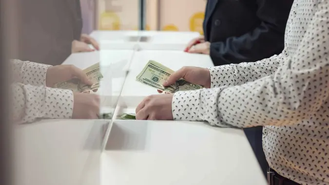 Male hand with money at cash desk.