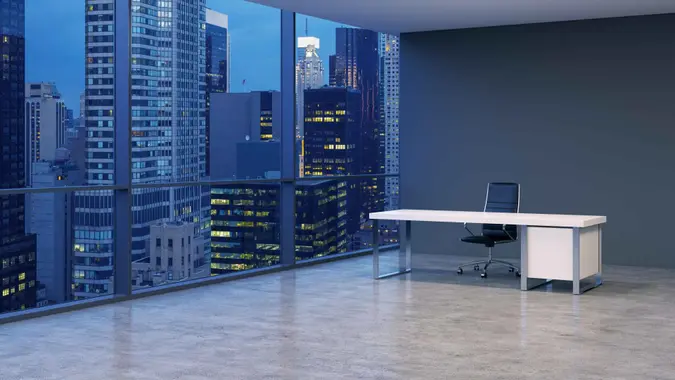 A workplace in a modern corner panoramic office with New York evening view.