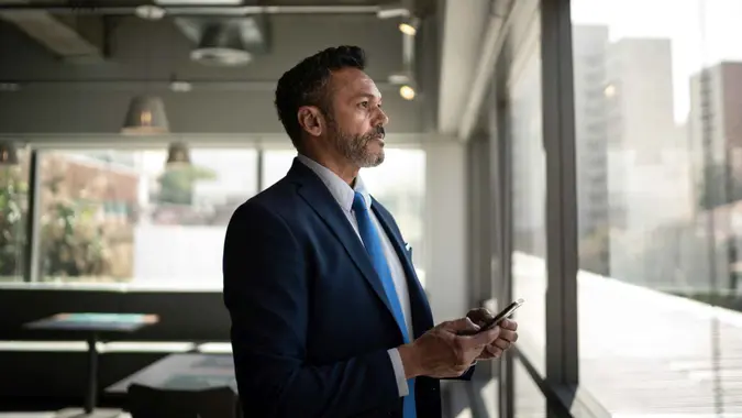 Serious businessman looking through the window.