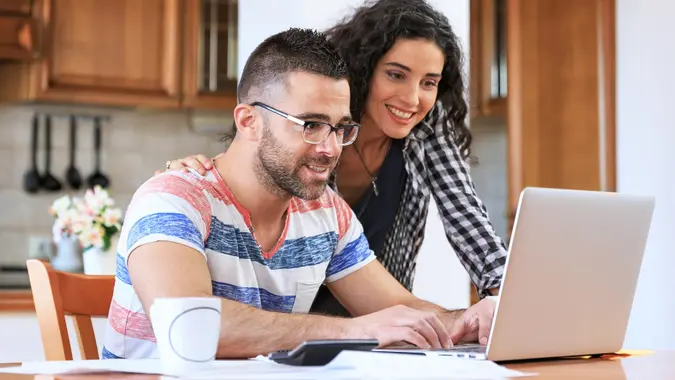 Couple using laptop at home stock photo
