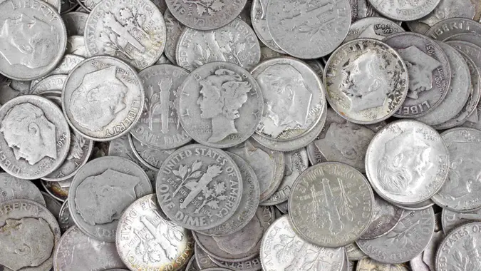 Old silver dimes on a white background.