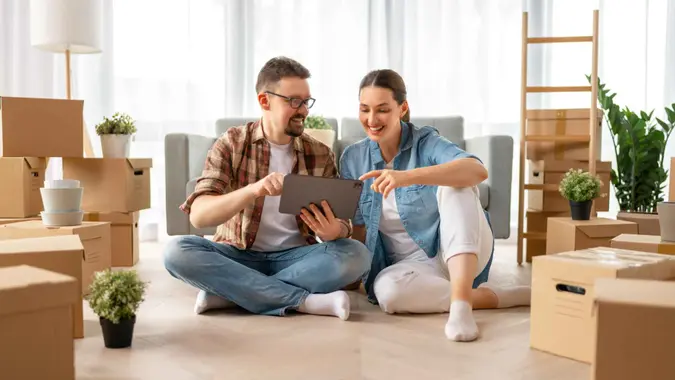 Happy young married couple are moving to new apartment.