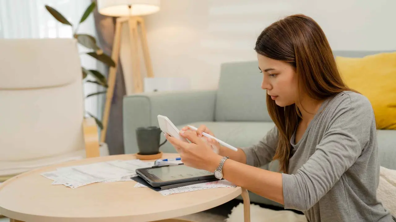 Asian women counting college savings fund, tuition fee for student loan with calculator.