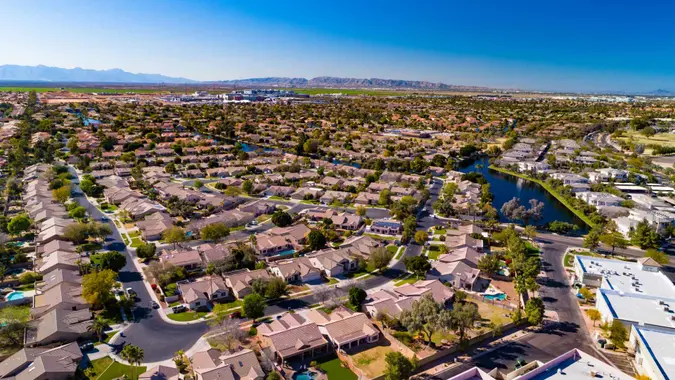 Aerial of residential areas of Chandler, Arizona, with South Mountain and the Sierra Estrella mountain range in the distance.