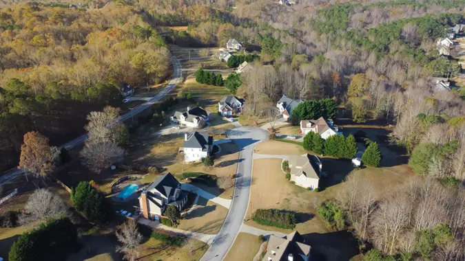 Lush suburban area forest park, low density residential of several dwelling units per acre, two-story houses with swimming pool, no-fenced yards near Atlanta, Georgia, USA.