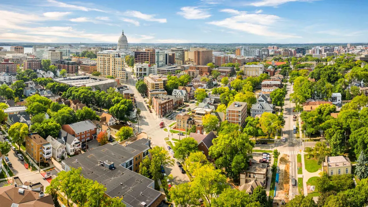 The Madison, Wisconsin skyline showing buildings, green trees and Wisconsin State Capitol on a sunny day