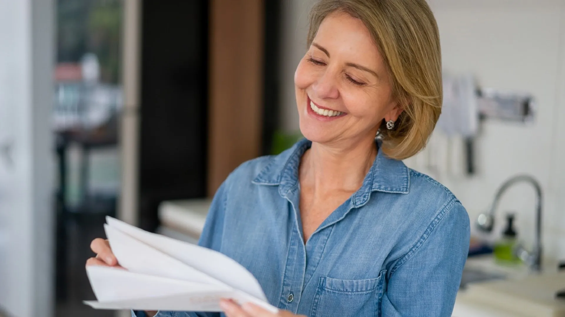 Woman smiles while checking paperwork.