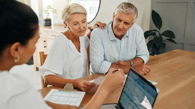 A retired couple sits with their financial adviser.