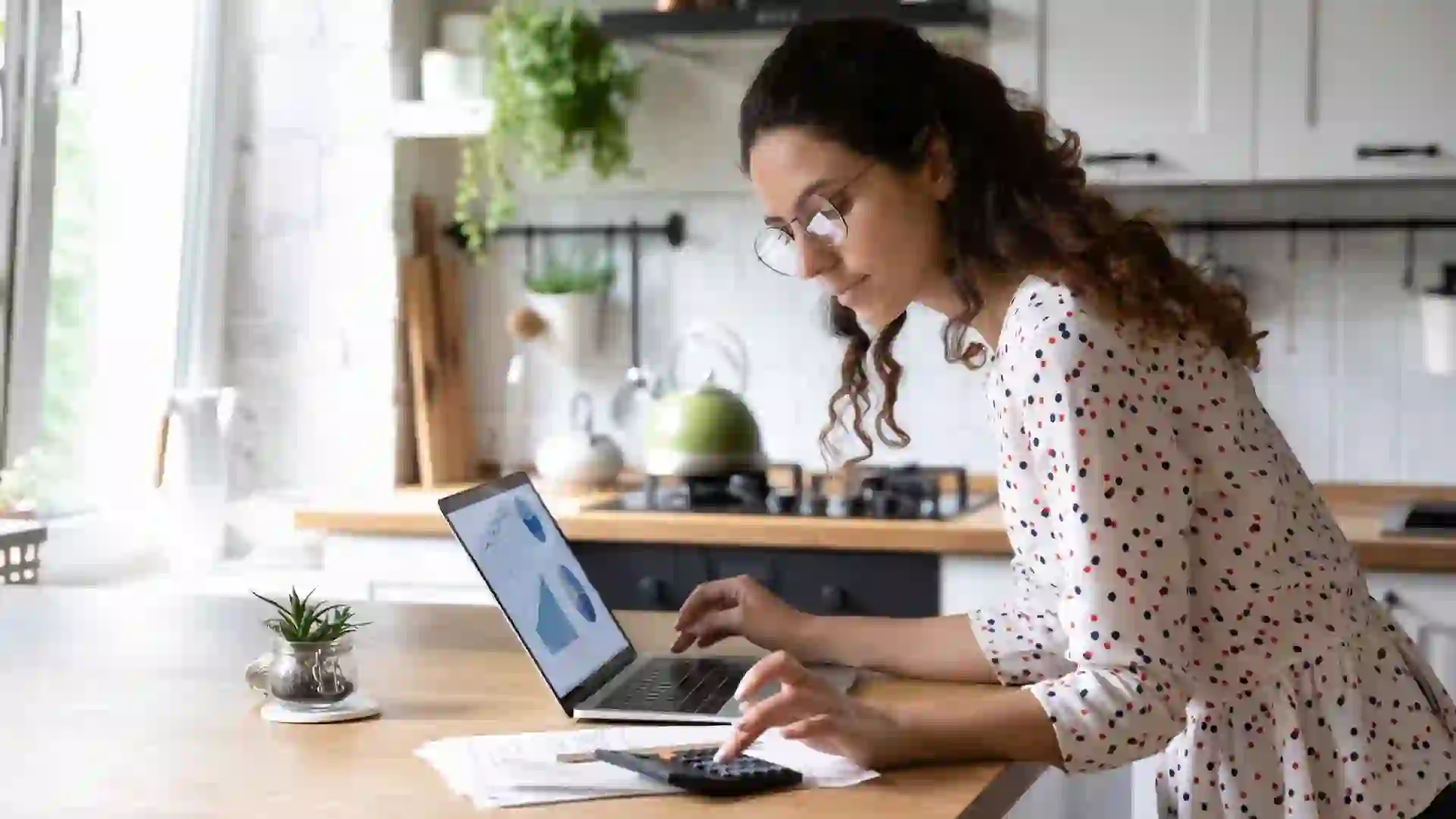 A woman looks at her computer and goes over her finances.