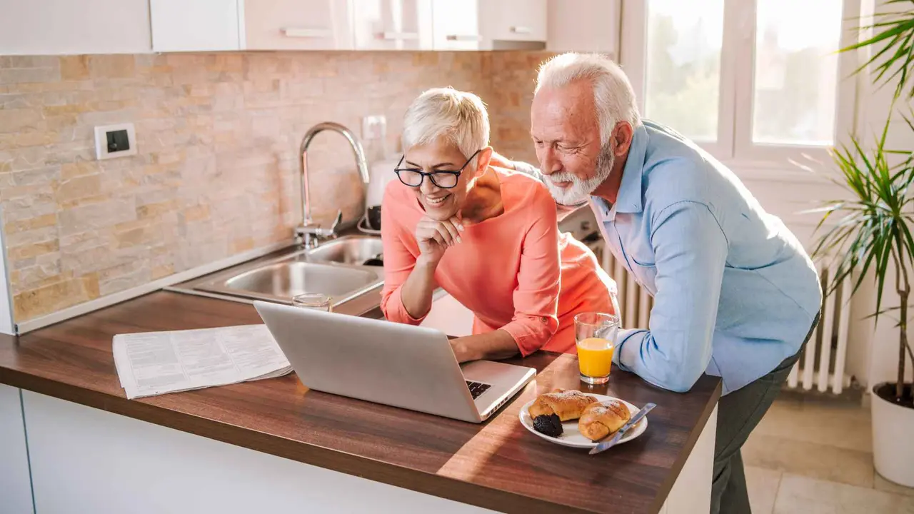 A senior couple reviews their finances online.