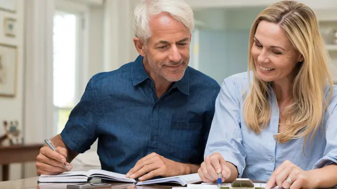 A retired couple goes over their finances while sitting at home.