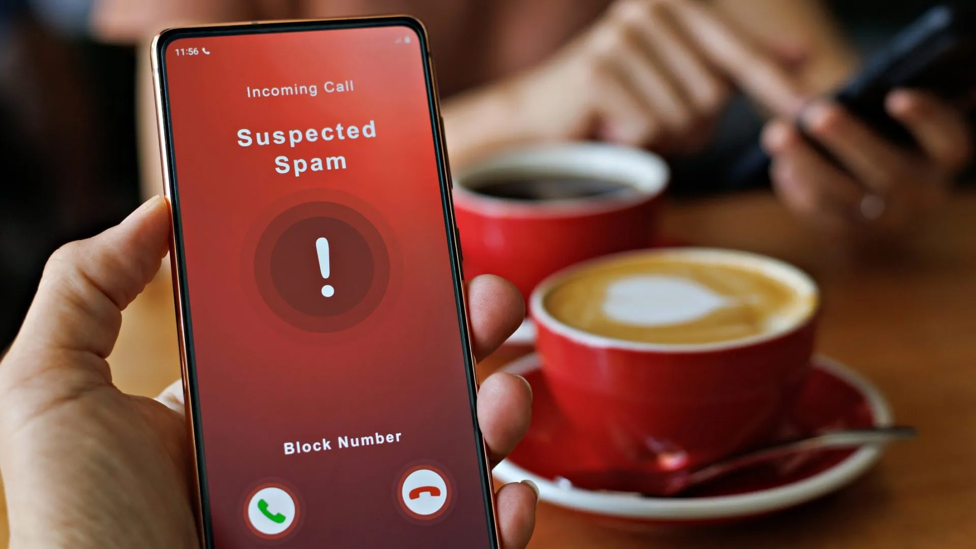 A man receiving an incoming suspected spam call on his phone.