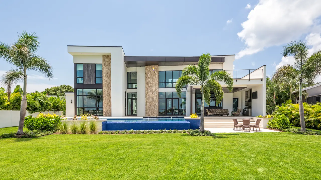 A beautiful modern home with landscaped backyard, swimming pool with waterfall and spa including an outdoor sitting area with TV.