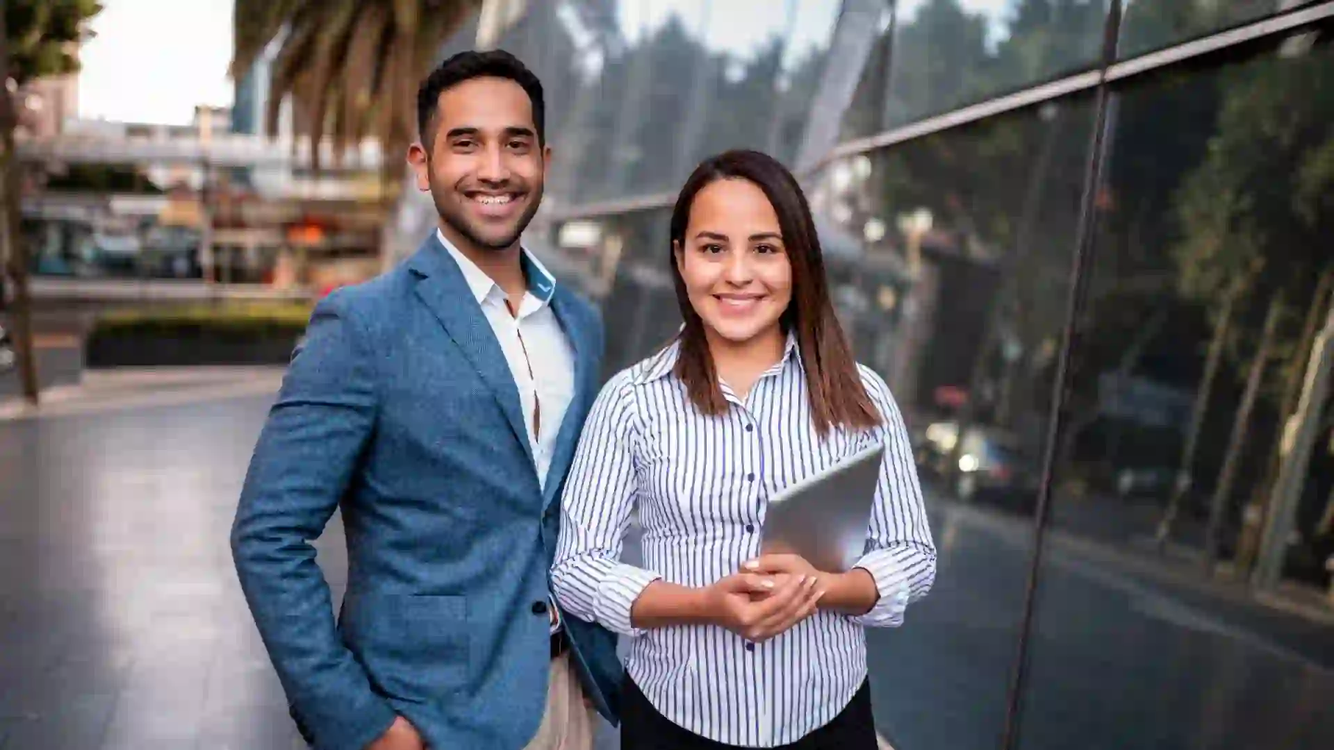 Portrait of businesswoman and businessman in front of the building.