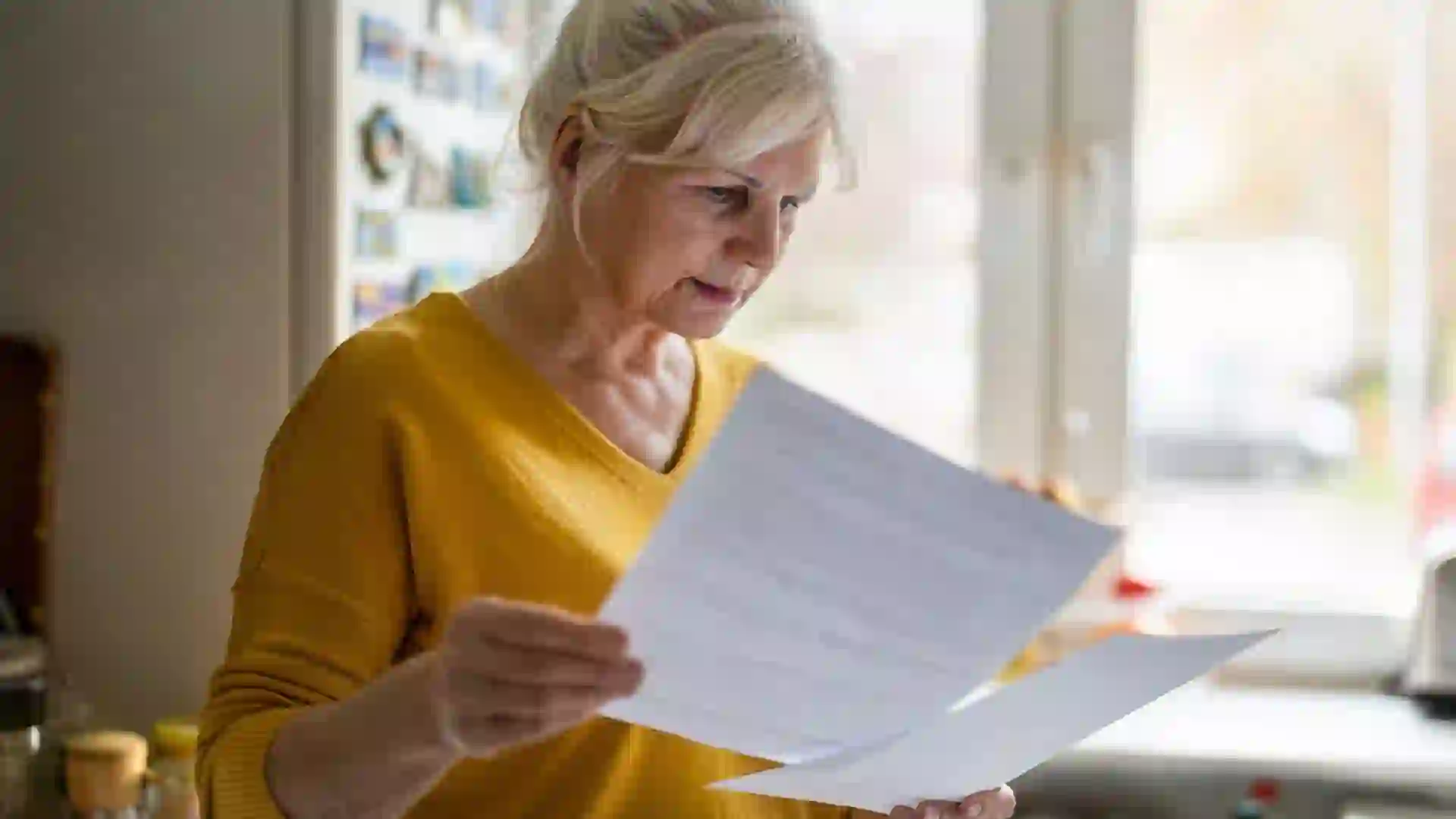 Senior woman filling out financial statements stock photo