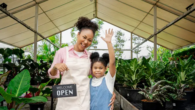 African American Single mom and her daughter in her green plant shop.