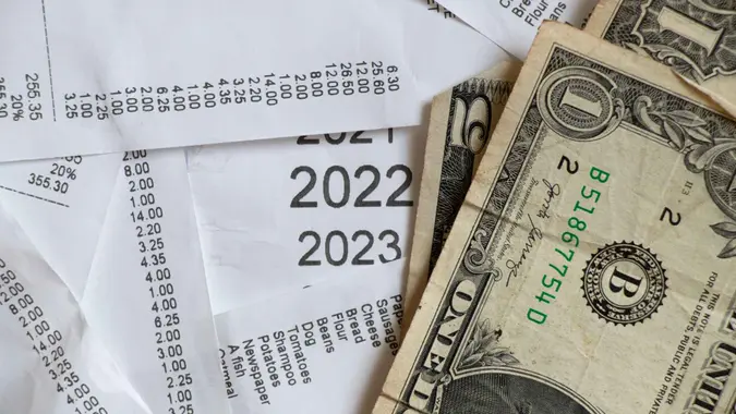 sales receipt from a supermarket with a shopping list and a list of years 2020 2021 2022 2023 on paper, calculating expenses and income by checks, results of the year, finance.