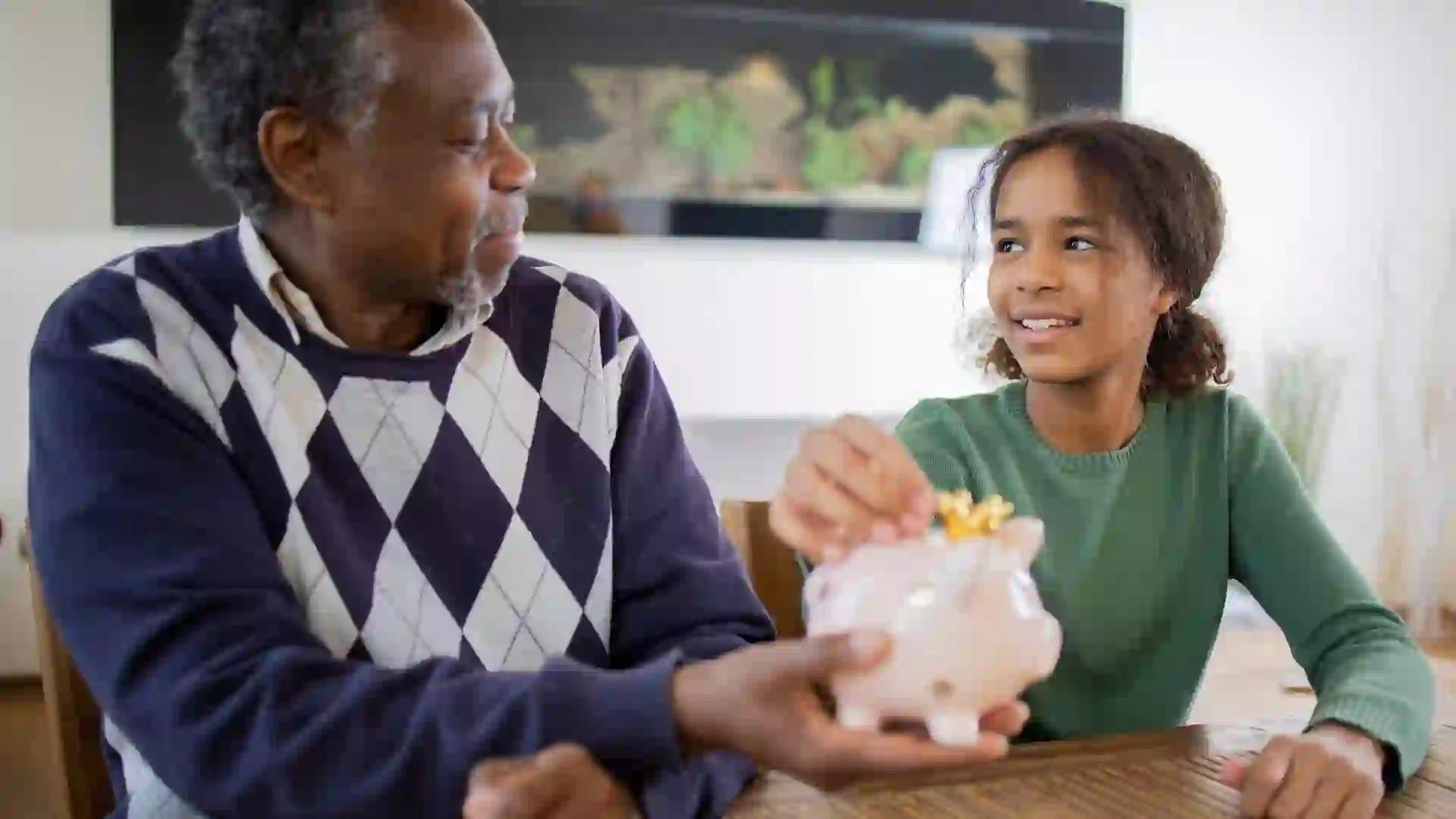 Grandfather teaches his granddaughter healthy saving habits stock photo