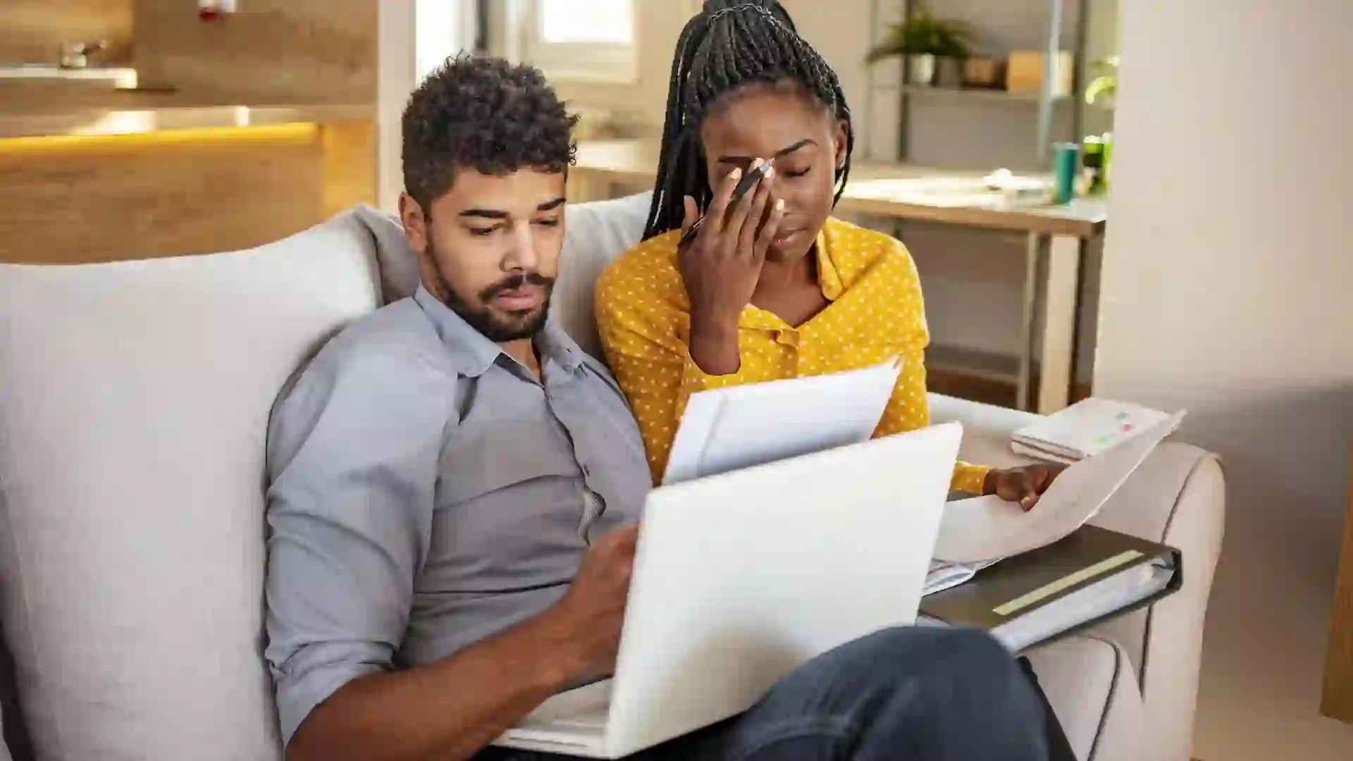 Stressed couple looking over papers related to bills, finances, mortgage, budget and other money issues.
