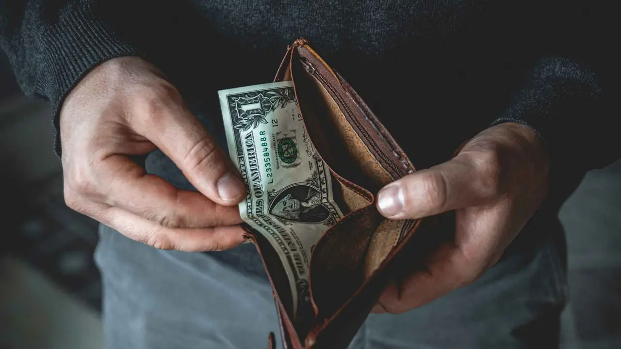 An Empty wallet in the hands of a young man.