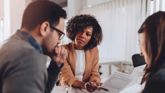 Couple preparing to sign a contract of sale and having second thoughts.