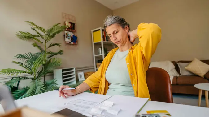 Photo of a woman calculating and paying online her income tax.