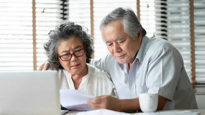 Senior Couple calculate their monthly expense with laptop computer.