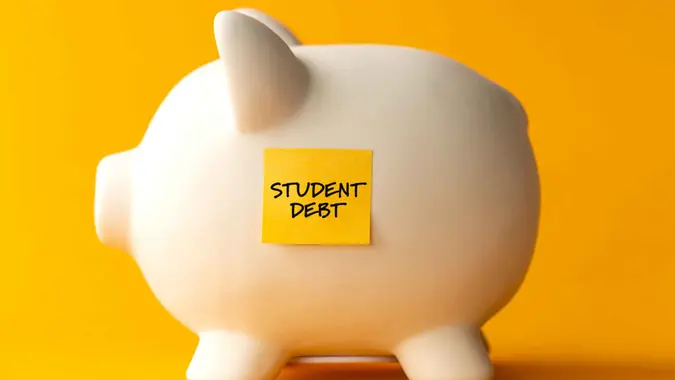 Piggy bank, adhesive note and student debt.