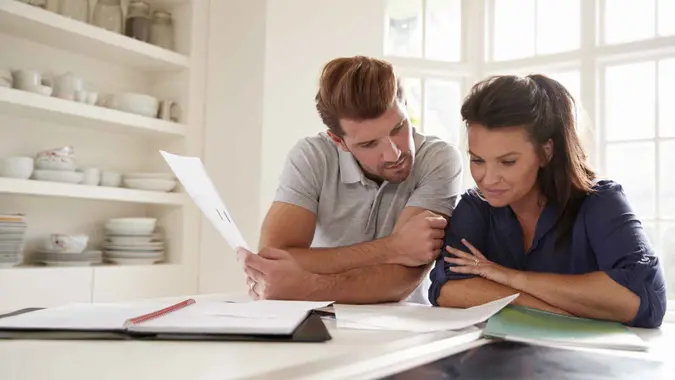 Couple Looking At Domestic Finances At Home Together.