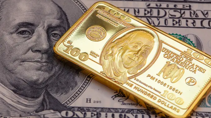US 100 dollar golden bar die cut stamp on US 100 dollar banknote background stock photo