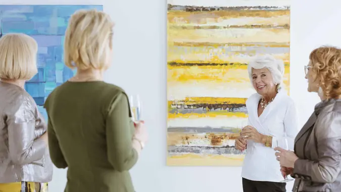 Group of senior women talking about the paint in gallery.