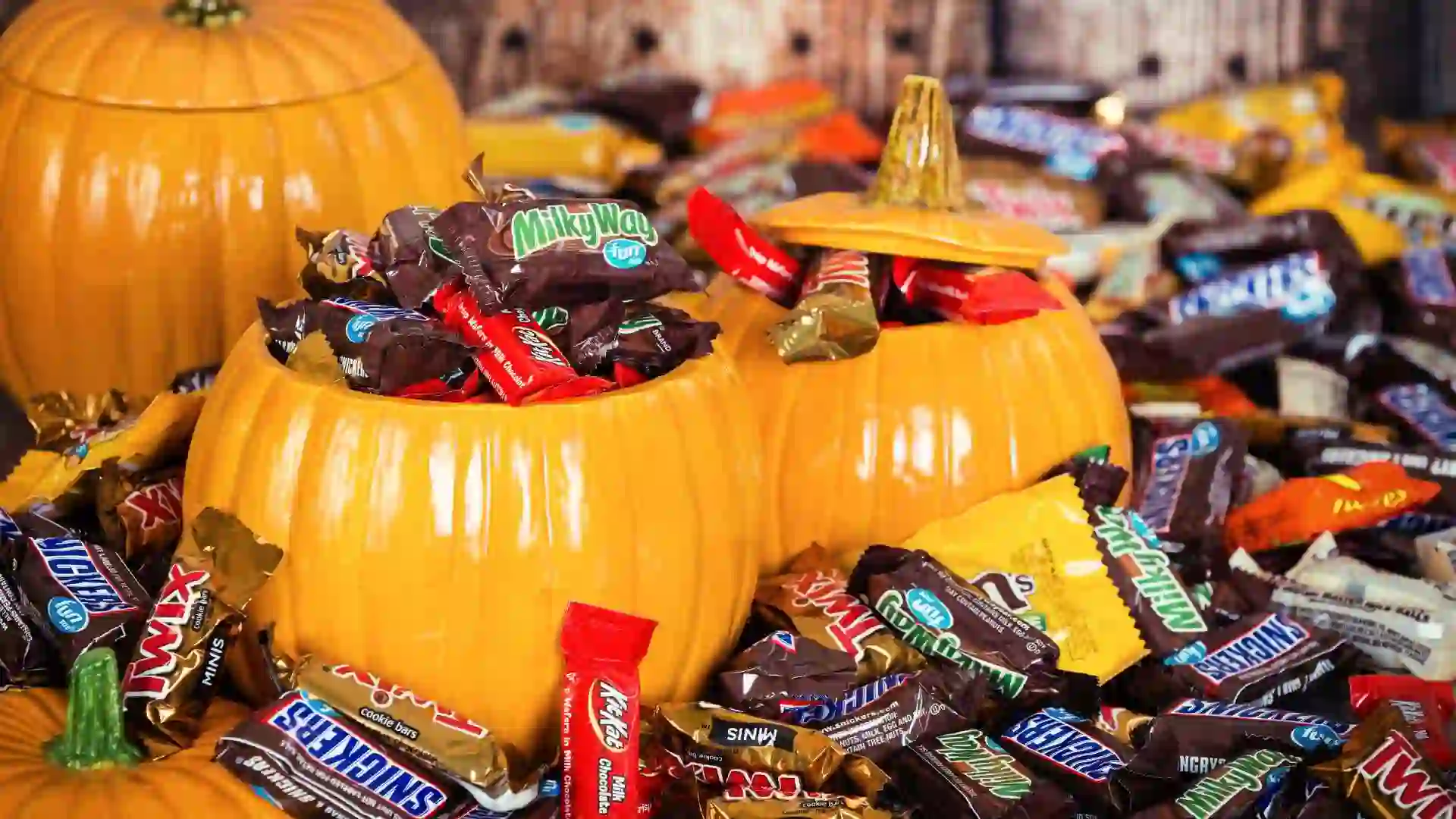 Dallas, United States - October 31, 2015: Decorative pumpkins filled with assorted Halloween chocolate candy made by Mars, Incorporated and the Hershey Company.