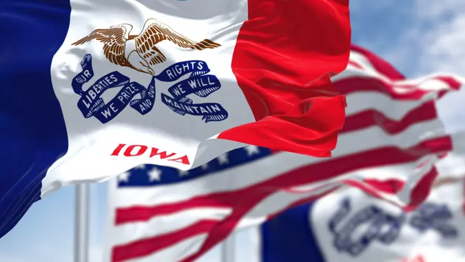 The Iowa state flag waving along with the national flag of the United States of America.