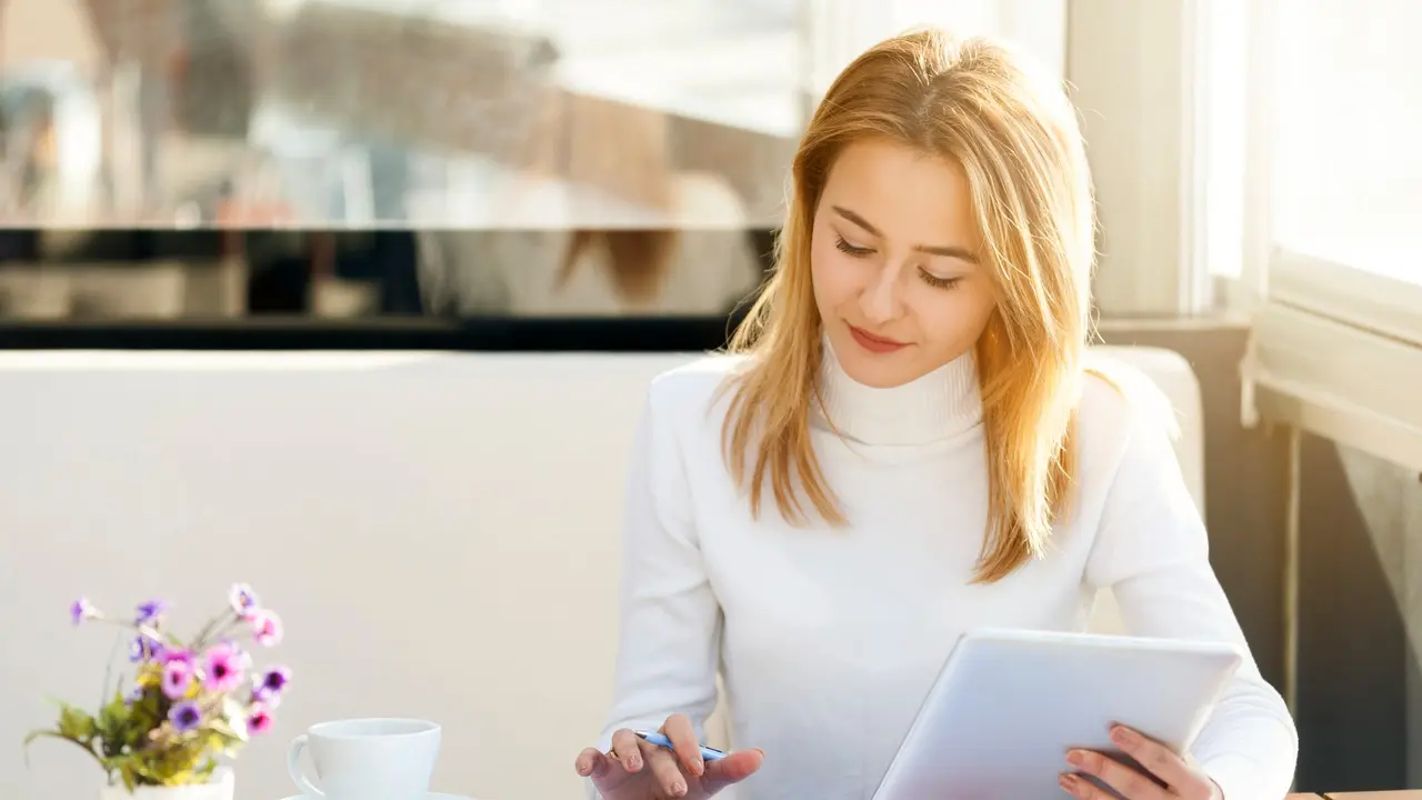 Woman working at her desk and managing her finances so she can become wealthy.