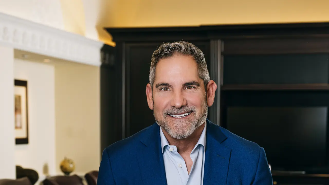 Grant Cardone smiling at the camera in a board room.