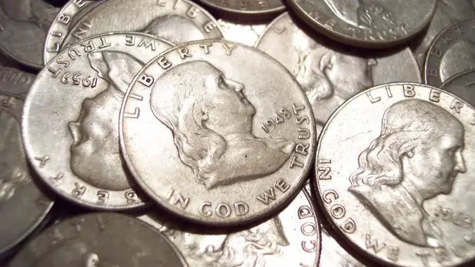 Macro of a pile of old silver Benjamin Franklin half dollars.