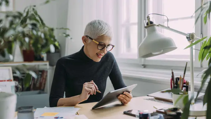 A woman smiles while sitting at her desk and doing work.