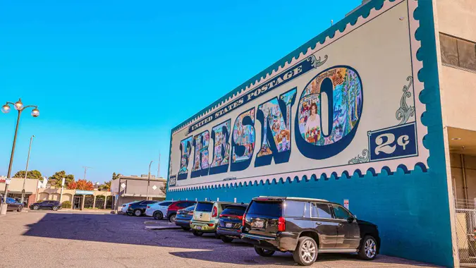 Fresno, United States – November 16, 2022: A closeup shot of the side of the Fresno Postage Stamp Mural with cars parked in front of it in the United States.