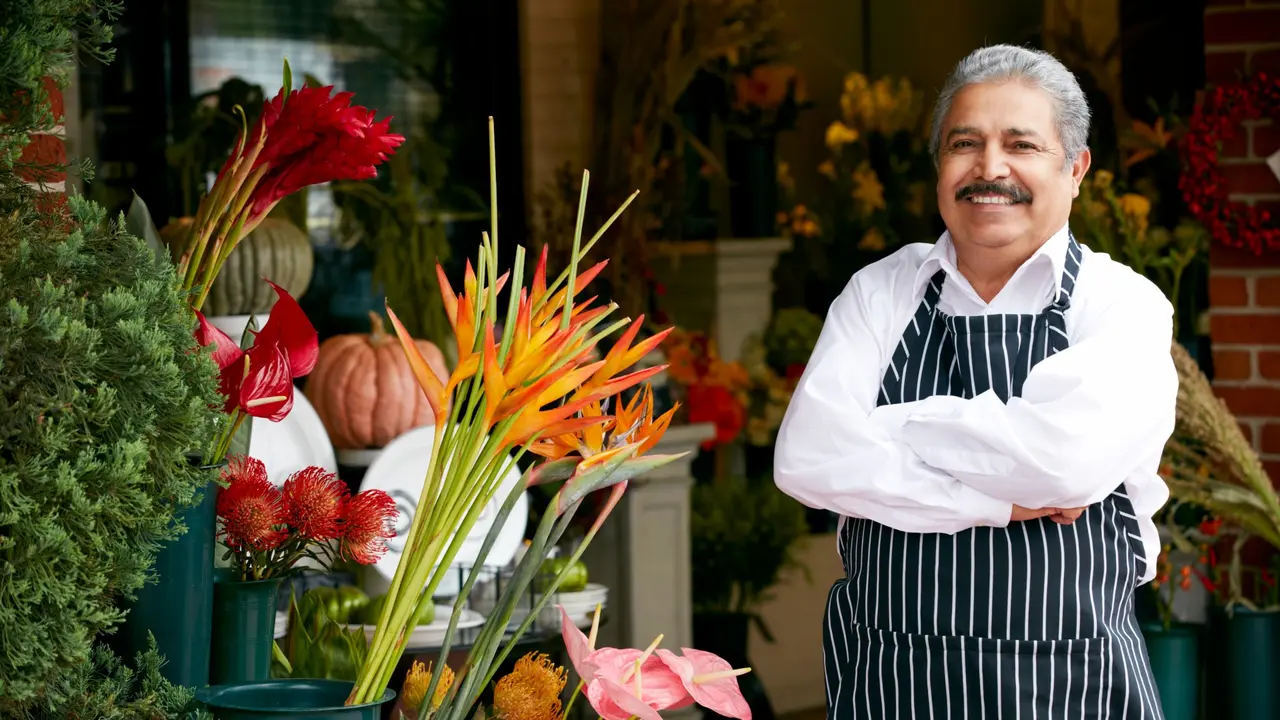 Man smiling and standing in front of a flower ship.