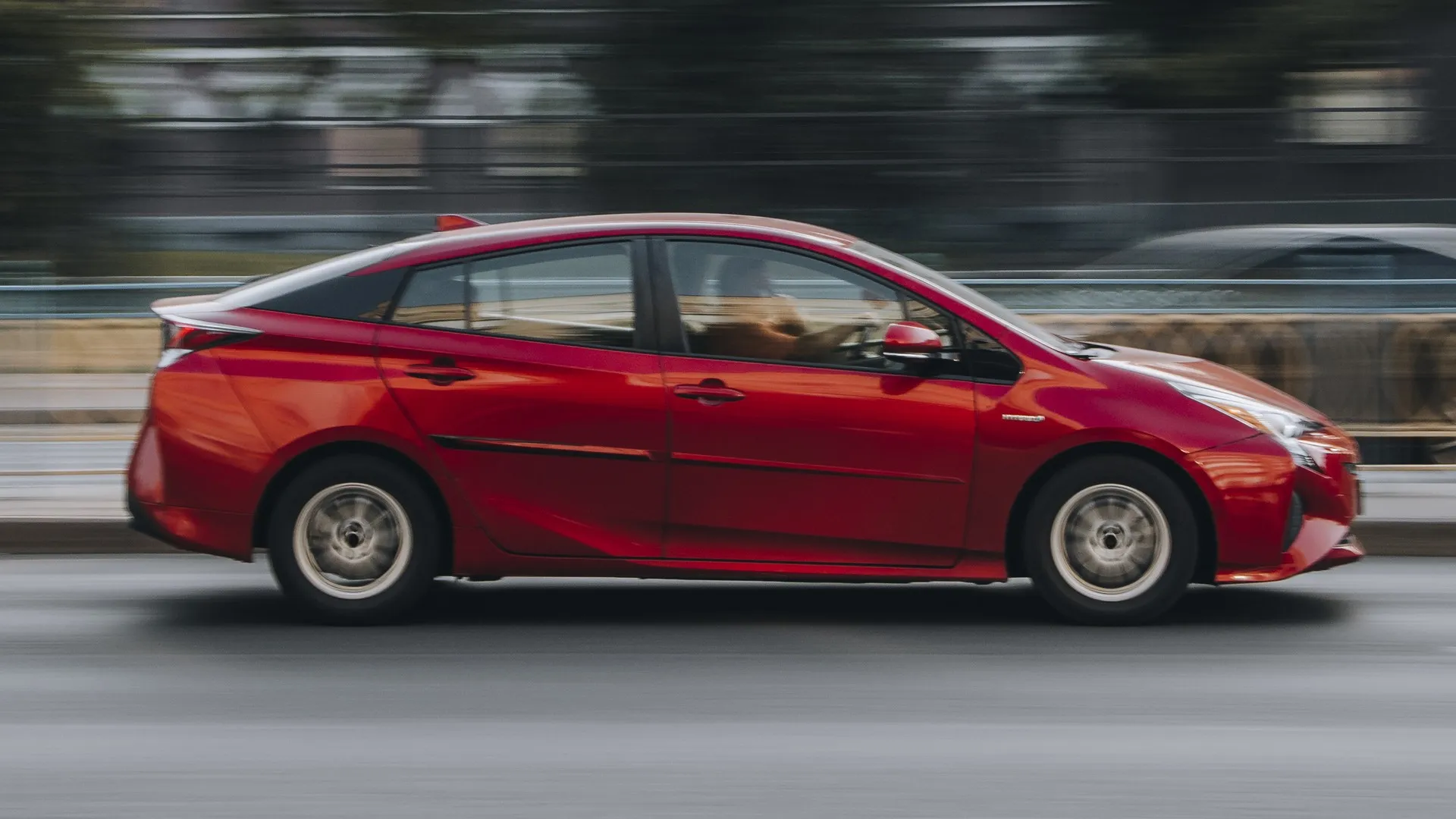 Red Toyota Prius car moving on the street. stock photo