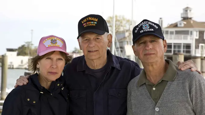Senior male and female military veterans wearing veterans caps.