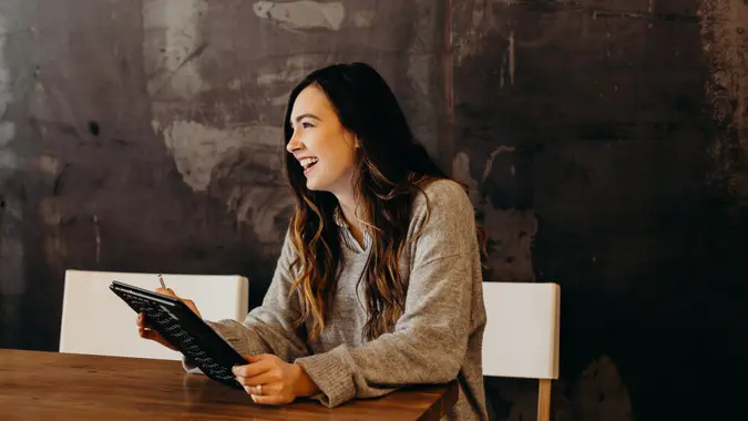 A woman at work, holding her tablet.