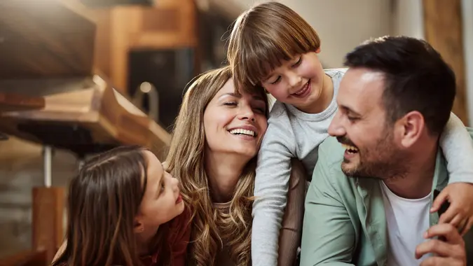 A family smiles and sits close to each other.