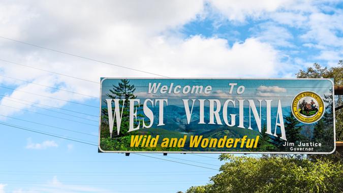 Kenova, USA - October 17, 2019: Welcome to West Virginia sign Wild and Wonderful with mountains picture and blue sky by Kentucky border.